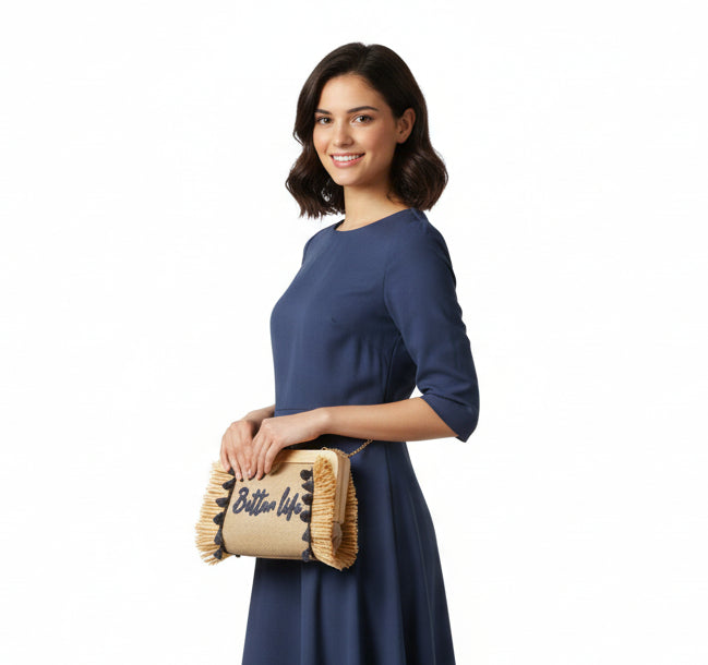 Beige clutch bag with 'Better Life' text and tassels on a white background