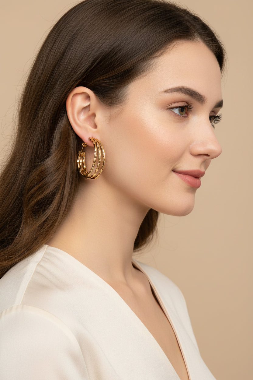 Gold triple hoop earrings on a white background