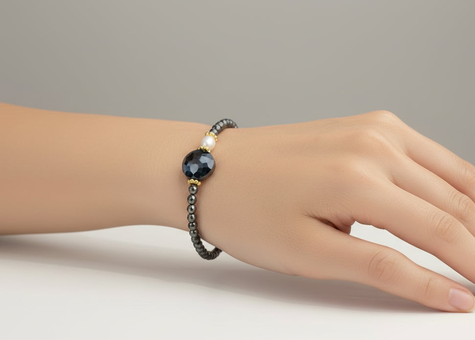 Bracelet with black beaded chain and large black bead on a light gray background