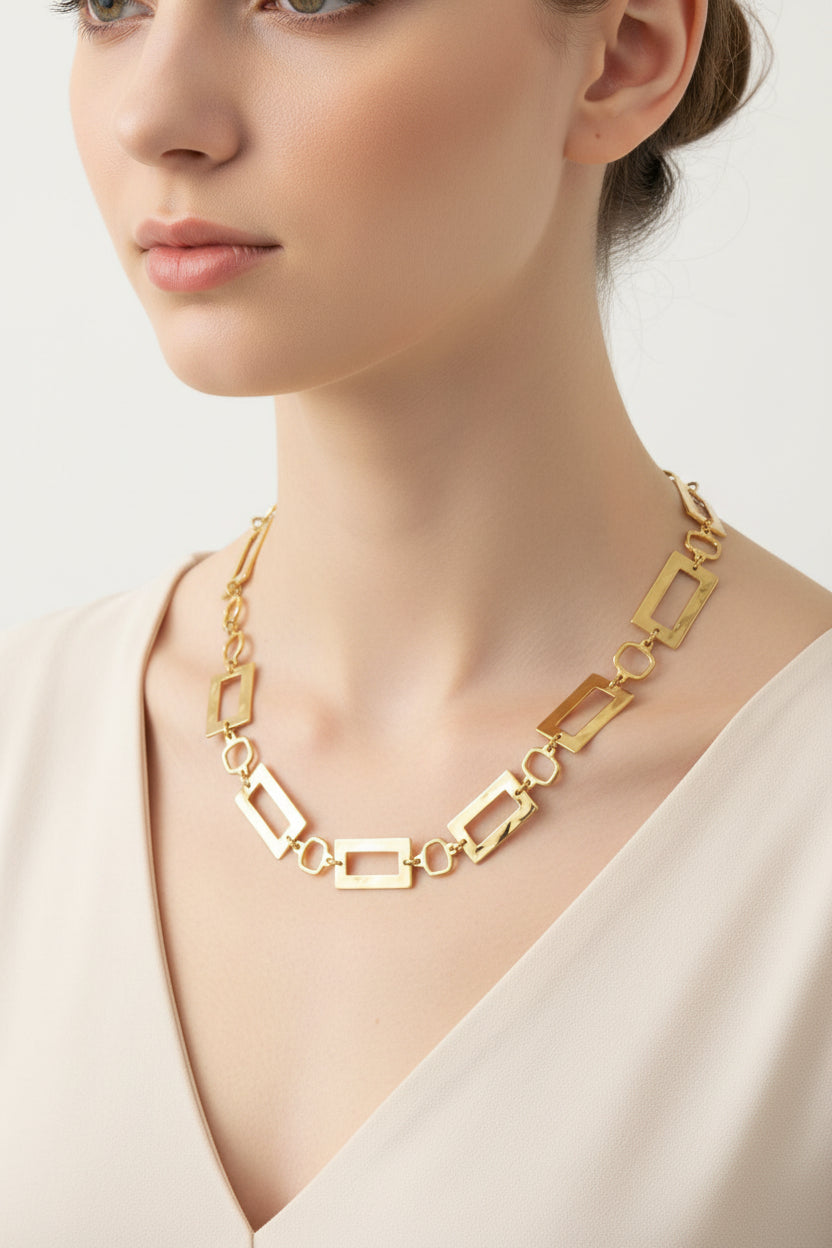 Gold chain necklace on a mannequin bust against a white background