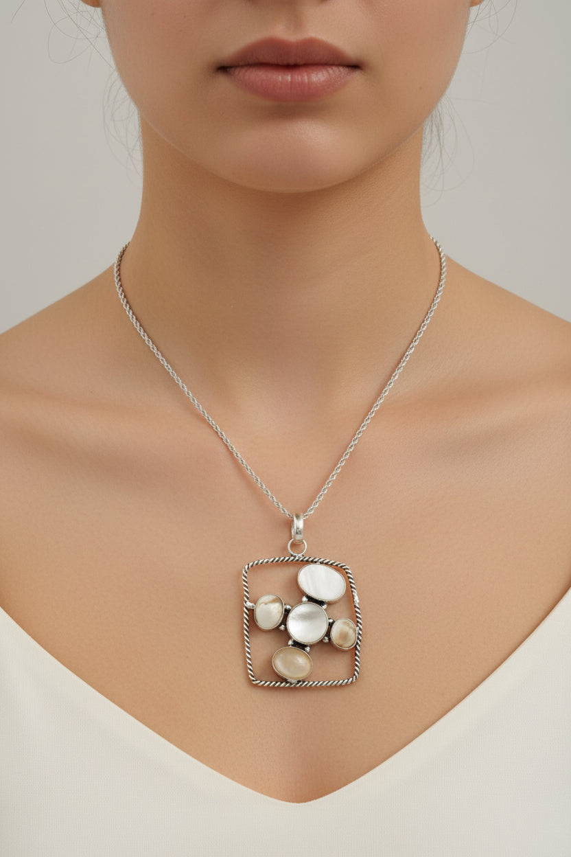 Necklace with a square pendant featuring circular elements on a woman's neck.