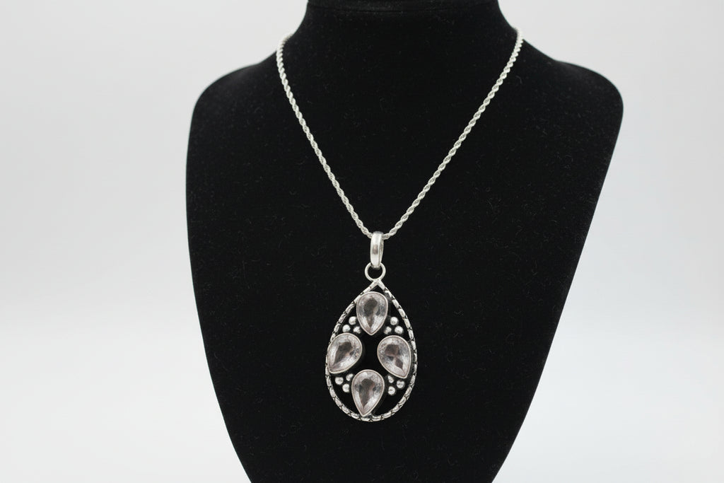Silver pendant necklace with crystalls on a black stand
