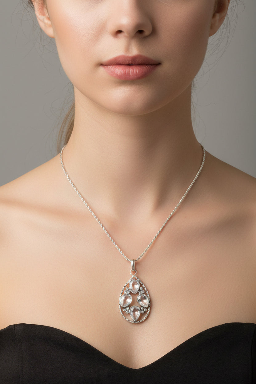 Silver necklace with a pendant on a woman's neck.