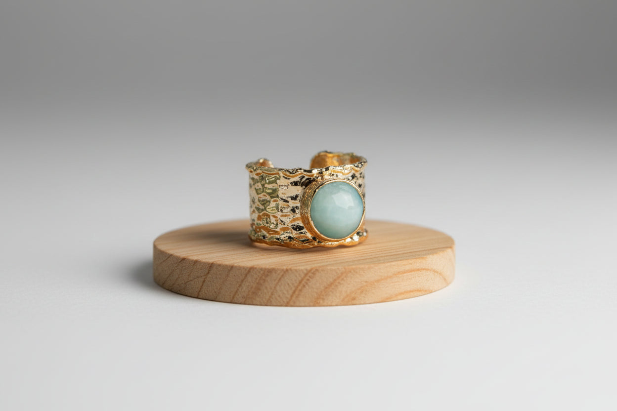 Gold rings with gemstones on a wooden surface 